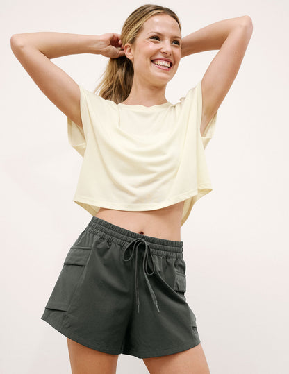Woman wearing Black Peak 3" Short™ with a cream cropped t-shirt, featuring side cargo pockets and a drawstring waist.