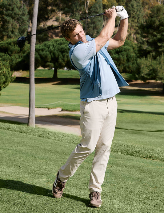 Man swings a golf club wearing the cream Element Men's Chino Trouser, featuring a straight leg, regular fit and side pockets.