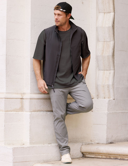 Man wearing the gray Element Men's Chino Trouser with a straight-leg fit, leaning against a white stone pillar.